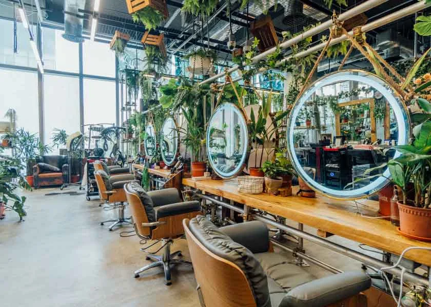 A cozy and vibrant hair salon filled with greenery and natural light at Walking On Sunshine.