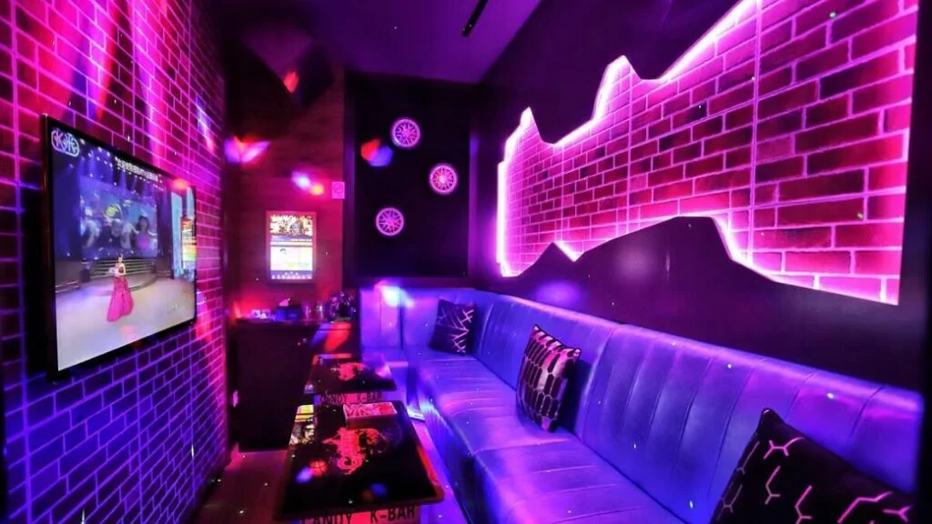 A family-friendly karaoke room with colorful murals and comfortable seating.