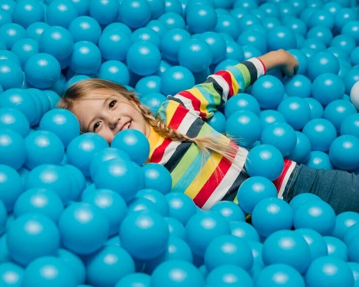 A child having fun in the colorful ball pit