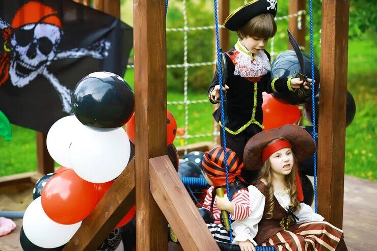 Children dressed as pirates exploring a ship-themed playground