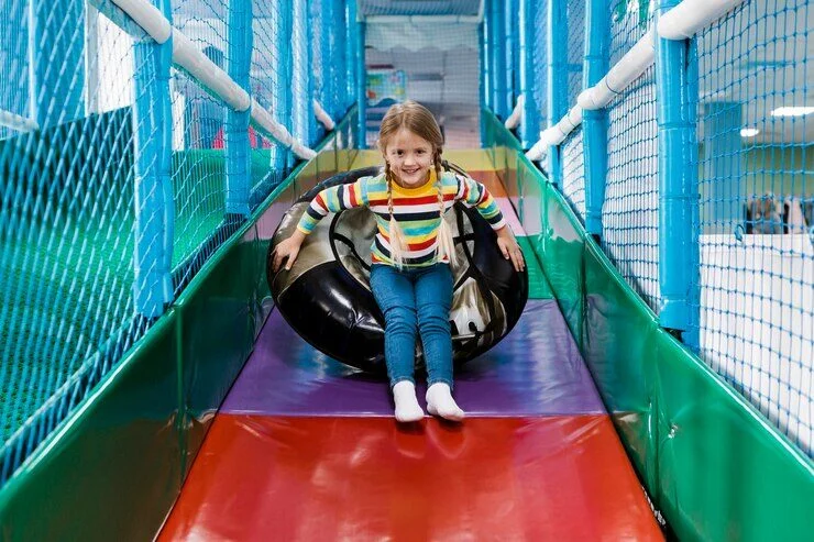 Kids sliding down the tall, multi-colored slides